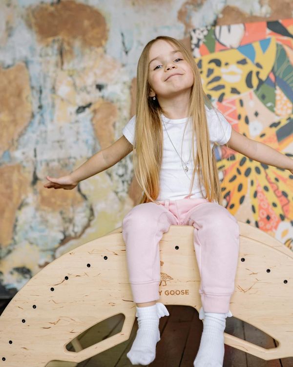 Happy child in a playful yoga pose on a colorful mat.